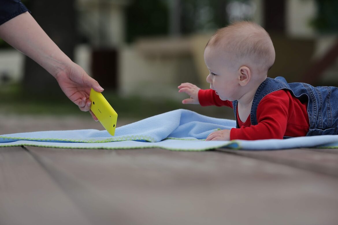 Baby die naar telefoon kijkt