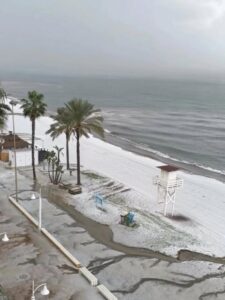 strand van Rincón de la Victoria kleurt wit na hagelbui