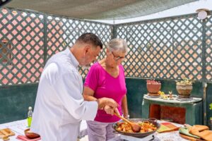 chef assisteert toerist 8.0 met het bereiden van een paella