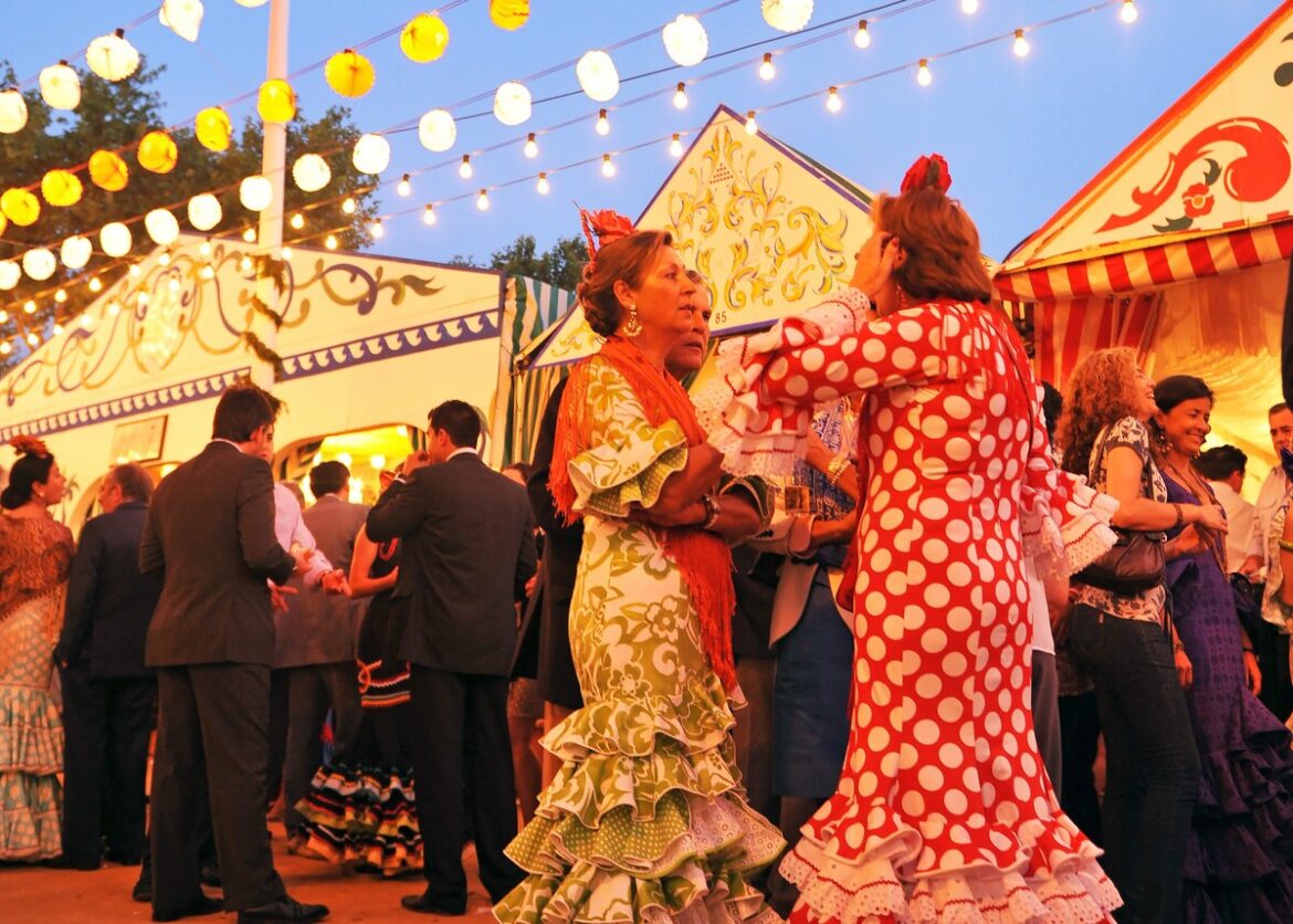 vrouwen in flamencojurken praten op de Feria de Abril in Sevilla