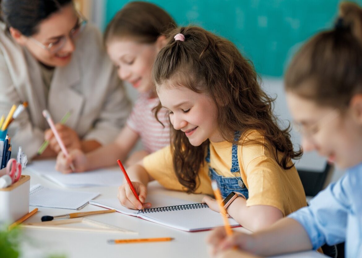 schrijvende kinderen in een schoolklas: PP wil meer papier en lezen
