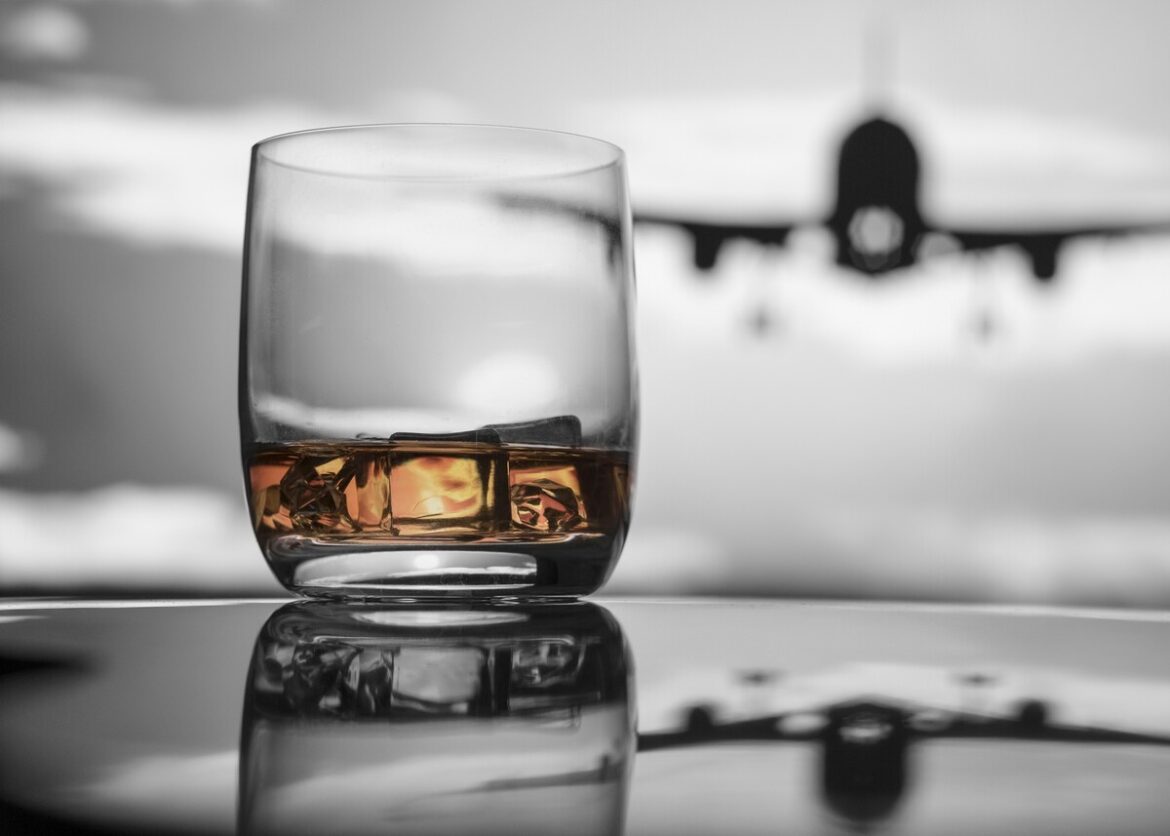 een glas wiskey in een vertrekhal van een luchthaven: Ryanair wil alcoholverkoop op luchthavens beperken