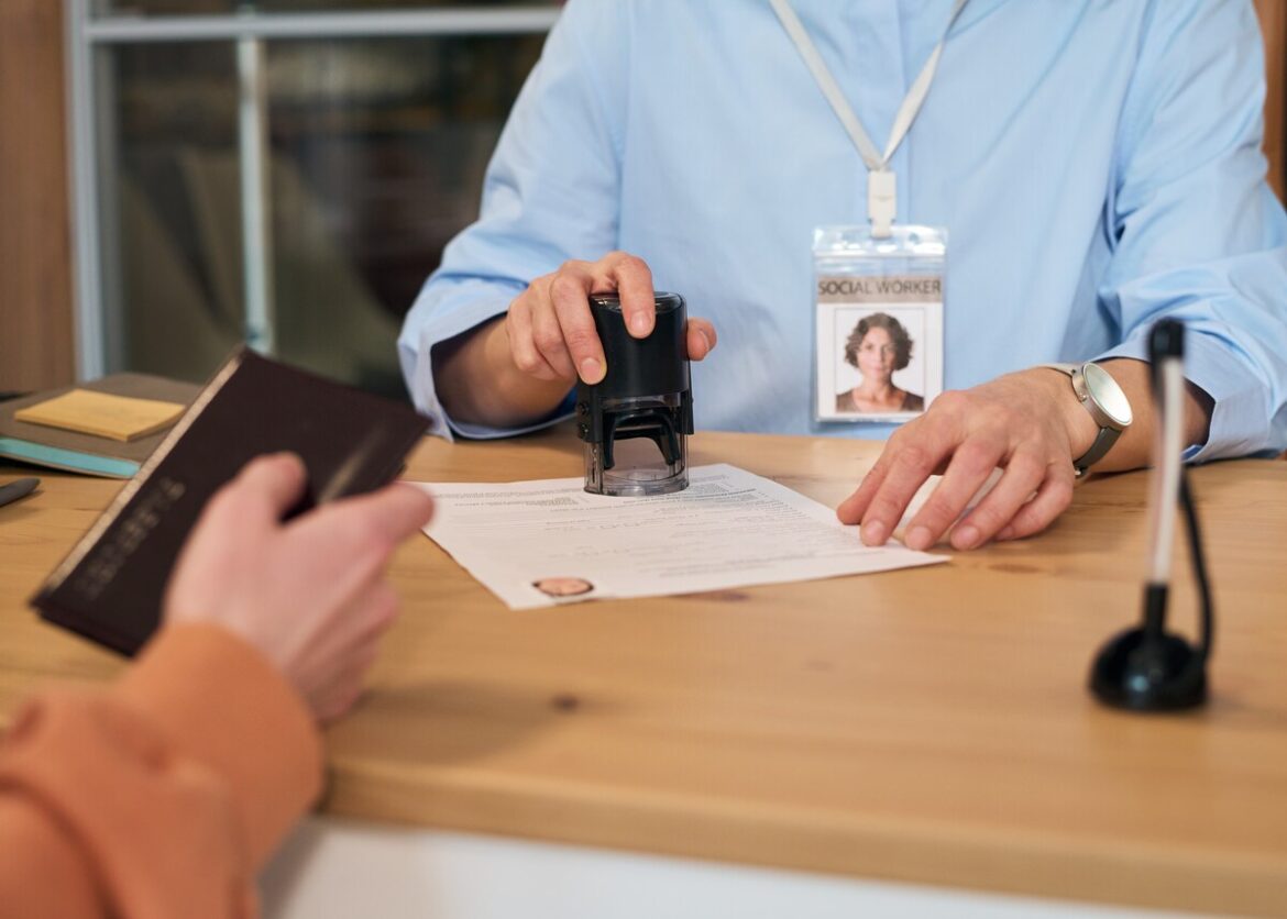 Vrouw zet stempel op een formulier bij een administratieve handeling: recordaantal migranten vraagt papieren aan in Spanje