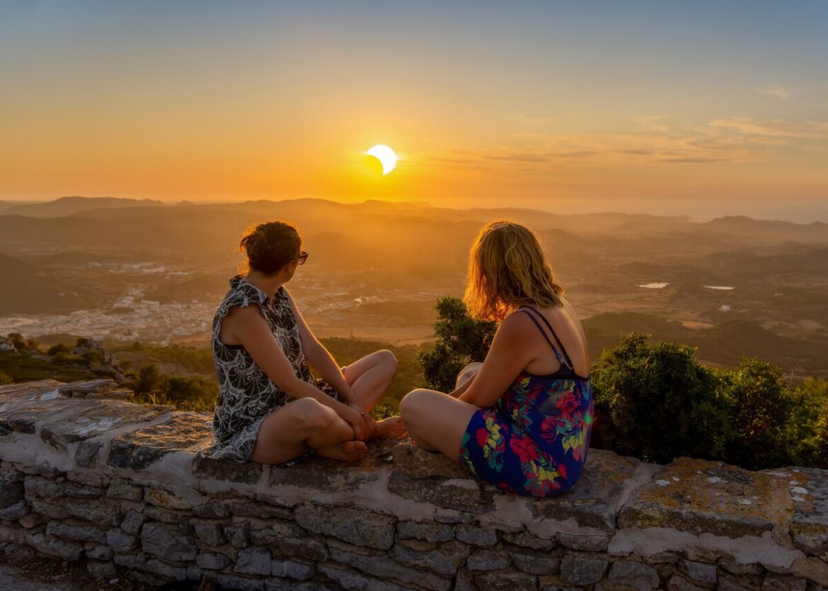 Twee vrouwen kijken naar een gedeeltelijke zonsverduistering op Menorca, Spanje krijgt de komende anderhalf jaar liefst drie zonsverduisteringen