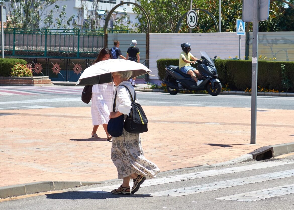vrouw loopt onder sunbrella in herfsthitte in Fuengirola (Málaga)