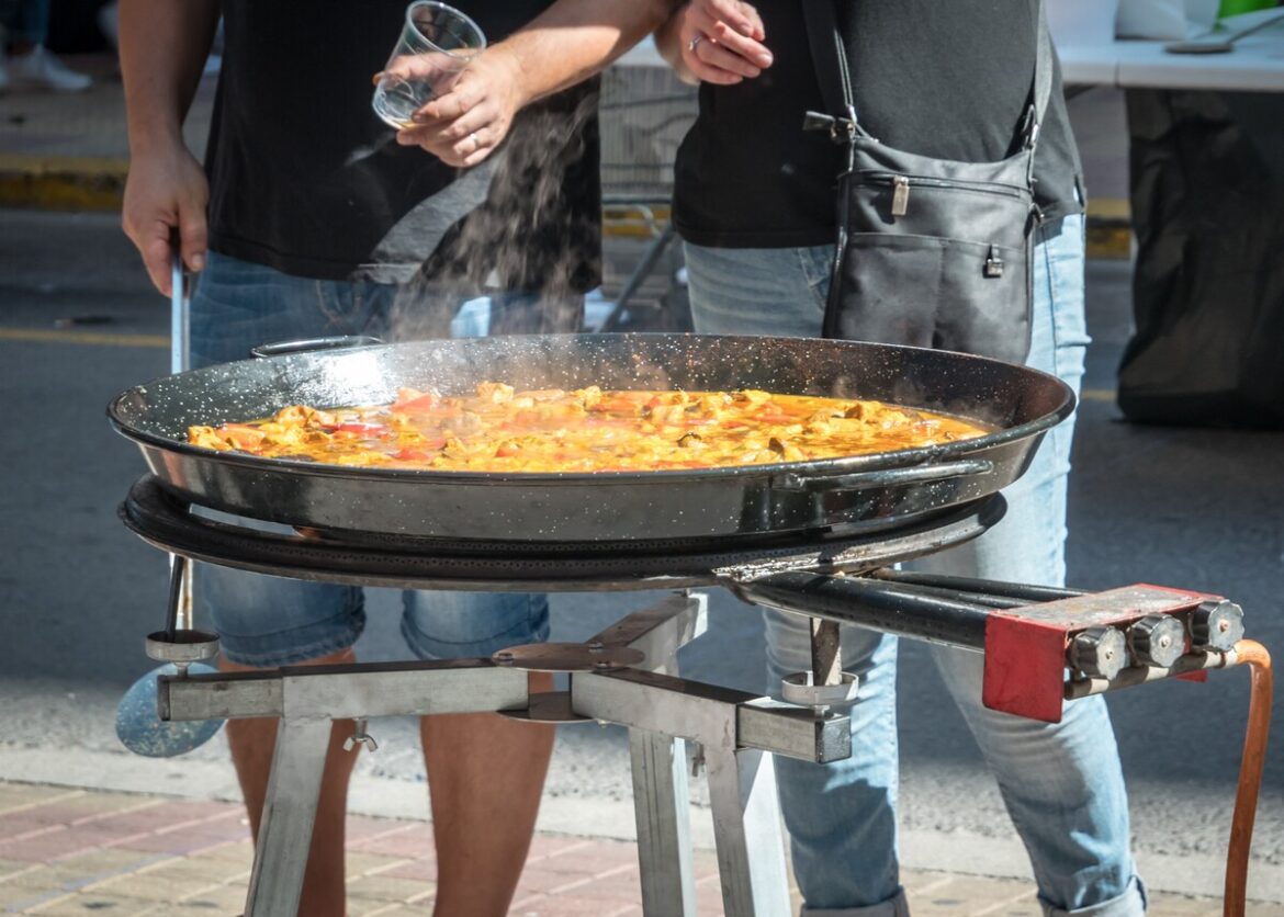 Twee mannen koken paella op straat in Cullera: dat zichzelf rijstwereldstad noemd